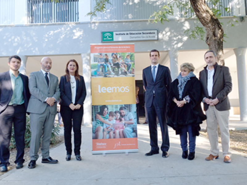 Grupo de personas en una presentación de educación, con un cartel promocionando el aprendizaje.