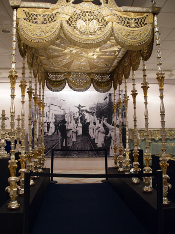 Elegante estructura dorada con detalles en forma de águila y corona, posiblemente parte de una exhibición de arte o cultura.