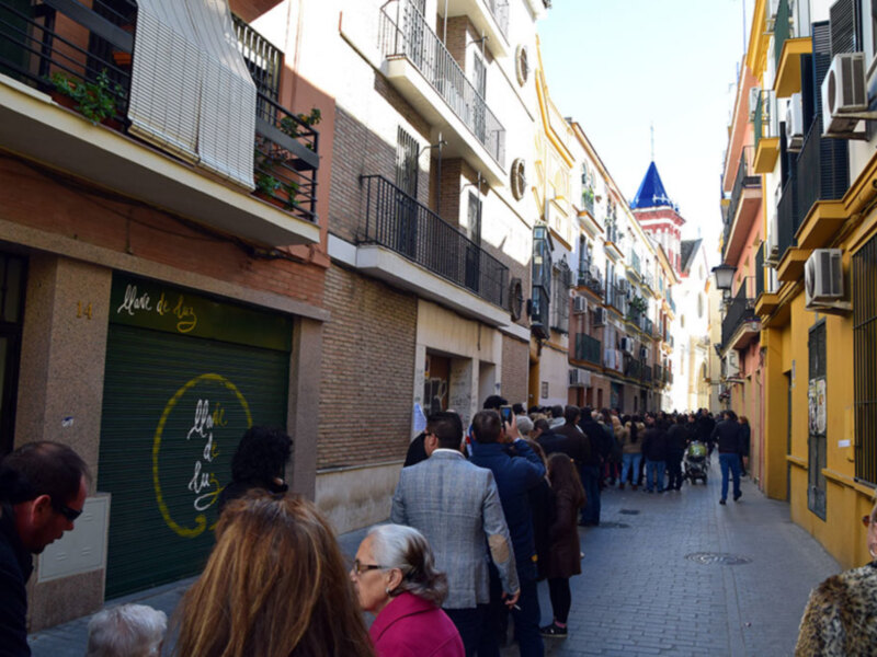 Calle con gente caminando en una ciudad europea, con edificios de colores y balcones.