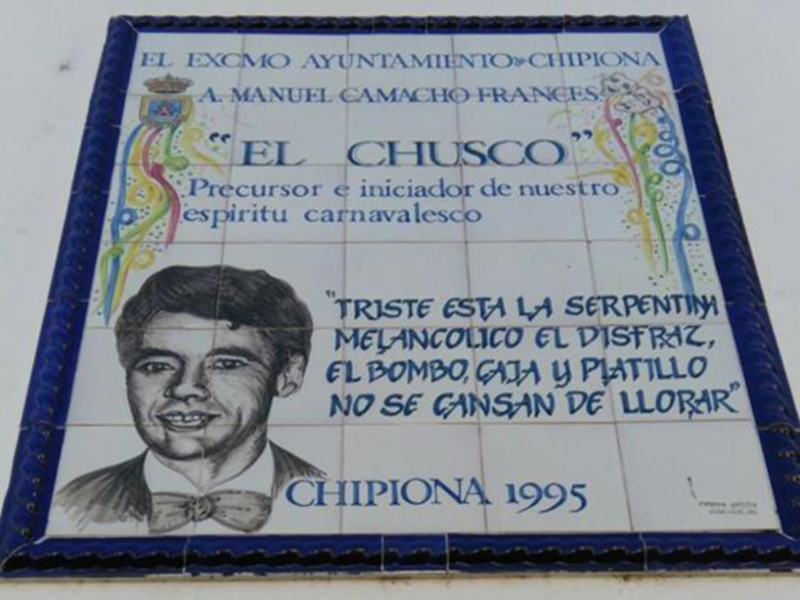 Placa conmemorativa dedicada a El Chusco, precursor y iniciador del espíritu carnavalesco en Chipiona, 1995.