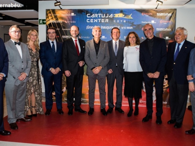 Grupo de personas posando en un evento formal, con un cartel de 'CARTUJA CENTER' en el fondo. El evento parece ser una inauguración o presentación.