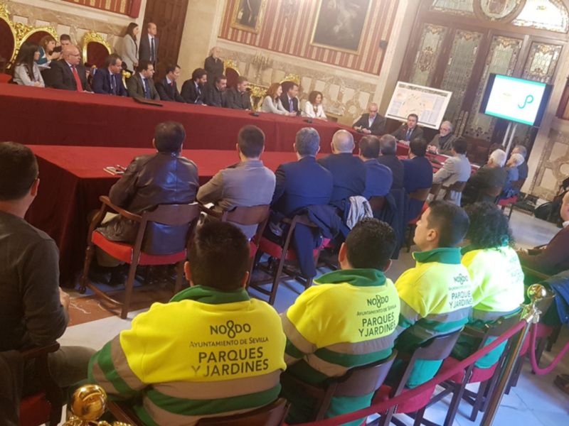 Reunión de trabajo con representantes de parques y jardines en un salón con decoración clásica.
