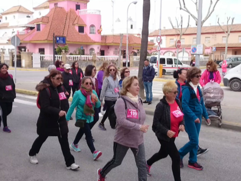 Grupos de mujeres participando en una carrera o caminata colectiva en una calle urbana.