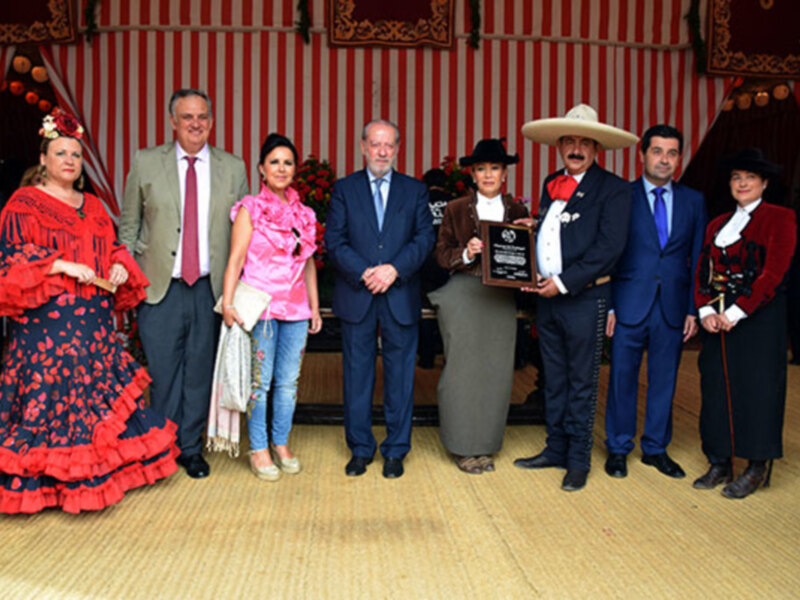 Grupo de personas en trajes tradicionales posando en un evento formal.
