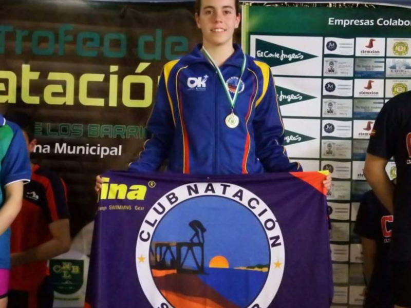Campeona del Club de Natación Sanlúcar con medalla y bandera del club.