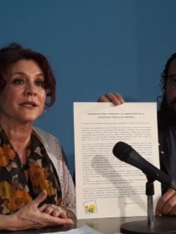 Persona hablando mientras sostiene un documento en una conferencia de prensa.