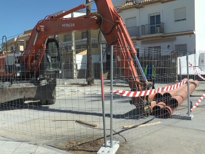 Excavadora Hitachi en obras de construcción frente a edificios residenciales.