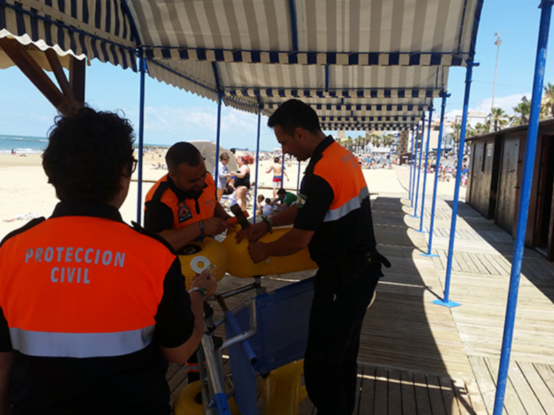 Personal de Protección Civil en la playa, preparando equipos de salvamento.