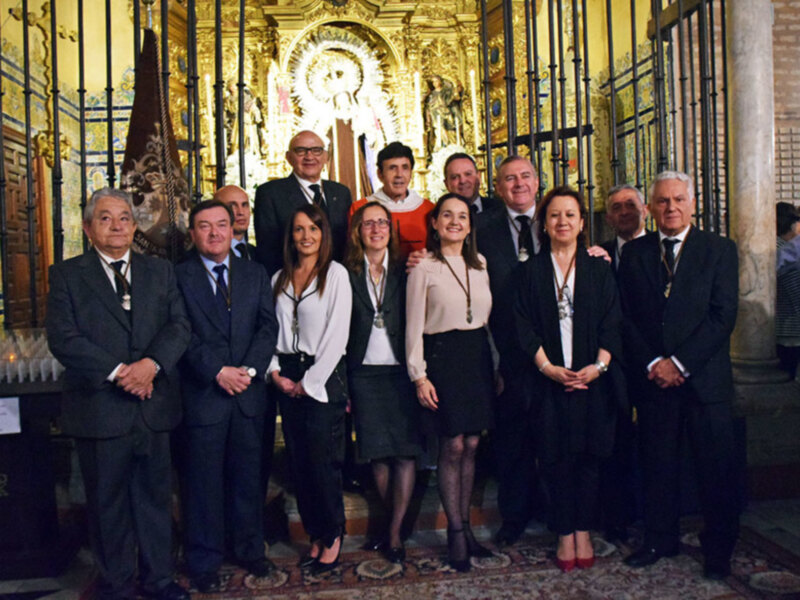 Gruppo di persone in abiti formali posano per una foto all'interno di una cattedrale ornata.