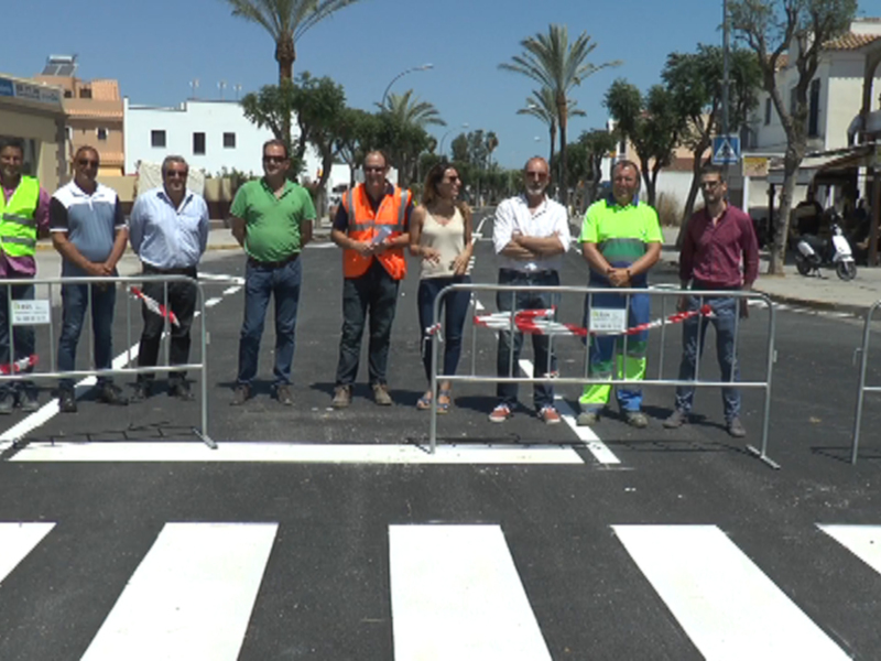 Equipo de trabajo posando junto a una nueva señal de peatones en una calle urbana.