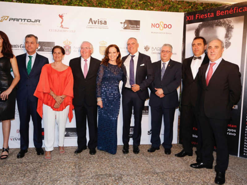 Participantes en la XII Fiesta Benéfica "La Es" en Sevilla, con patrocinadores como Pantoja y Avisa.