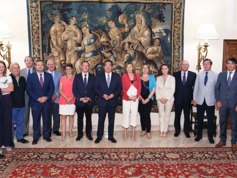 Reunión formal en un entorno formal con una tapicería histórica en el fondo.