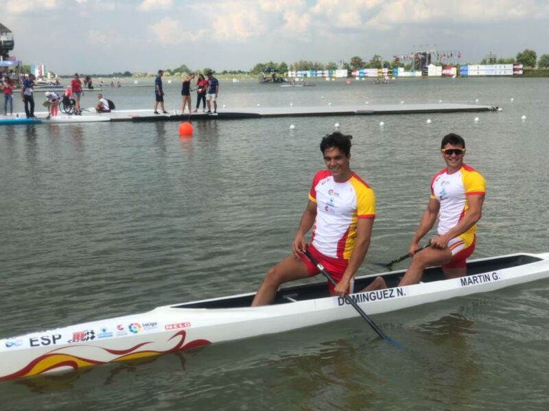 Dos atletas en un bote de remo en un evento deportivo en el agua.