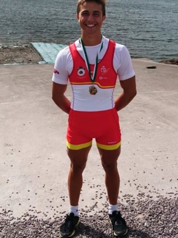 Un atleta de remo posa con una medalla en el estanque de la localidad de Cuenca, España.