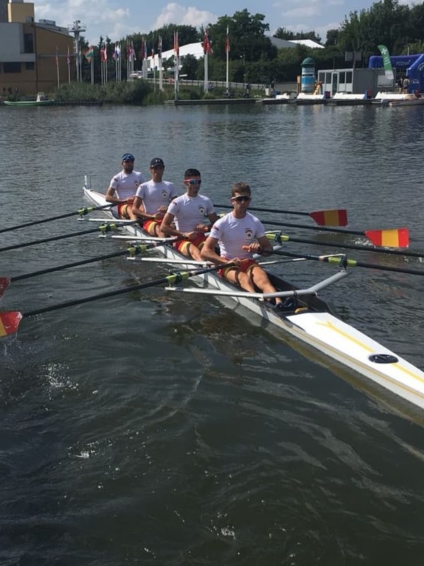 Equipo de remo en una canoa durante una competición en un lago.