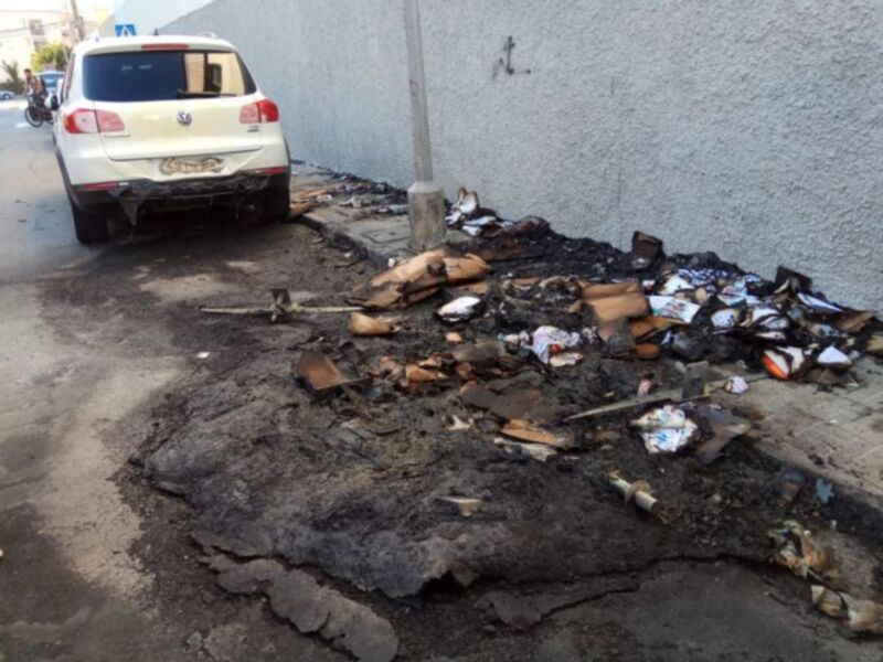 Vehículo dañado en la carretera con desperdicios en el camino.