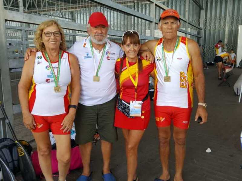 Fotografía de un equipo de remo con medallas en un evento deportivo.