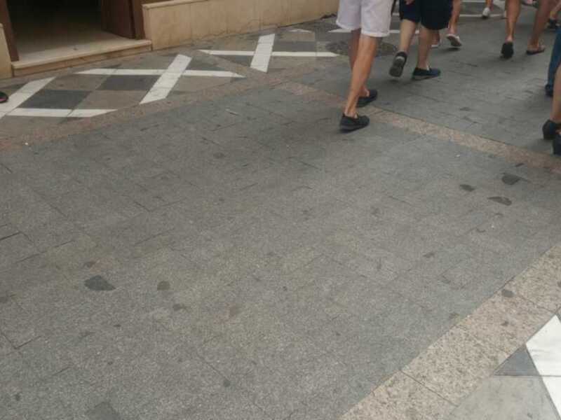 Piso de granito con patrones geométricos y personas caminando en el fondo.