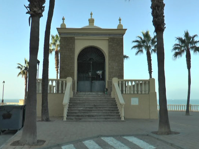 Elegante arquitectura con escaleras y palmeras frente al mar, iluminación y valla de metal.
