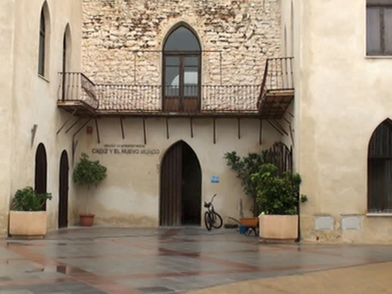 Exterior del Museo de Interpretación de Cádiz y el Nuevo Mundo, con arquitectura histórica y jardines en el patio.