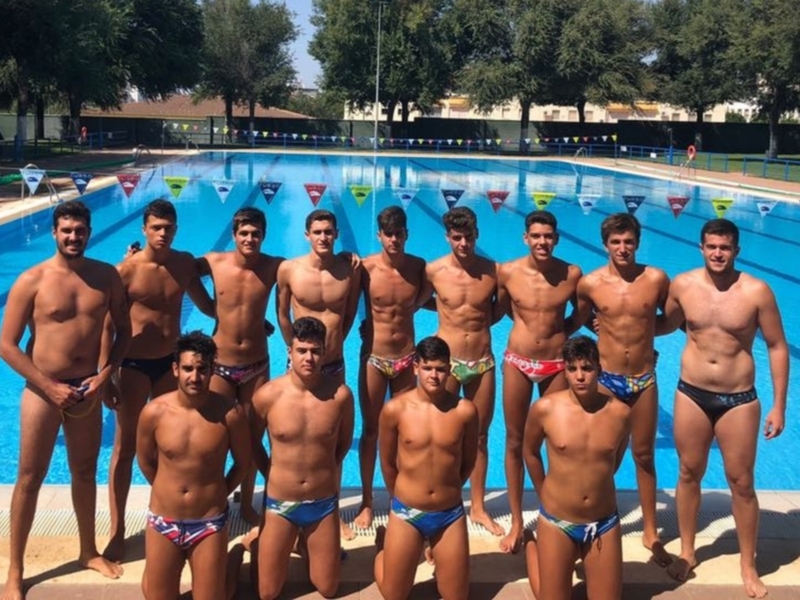 Equipo de natación posando junto a la piscina.