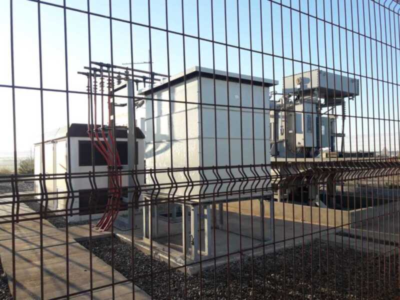 Estación de transformación eléctrica protegida por una valla metálica.
