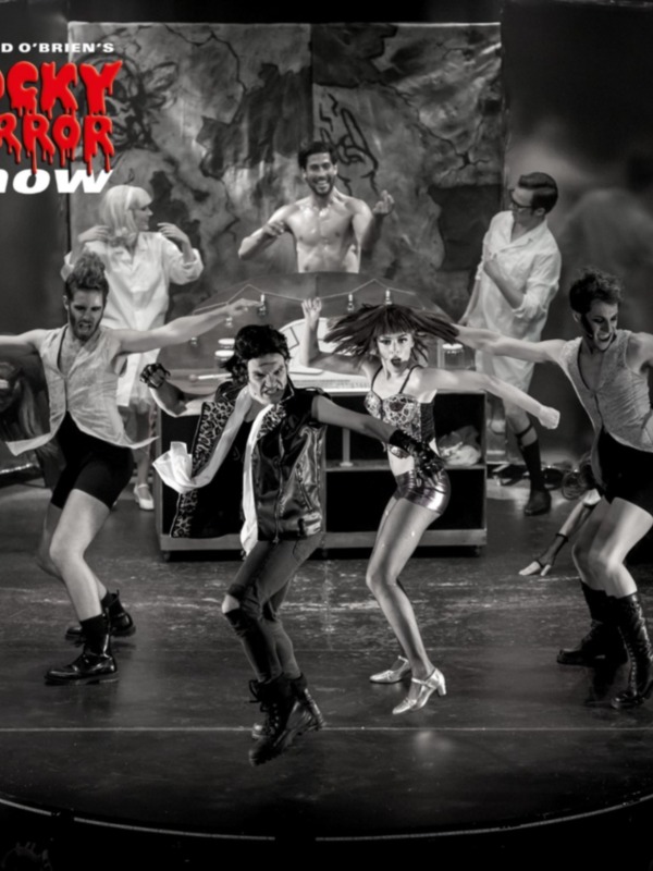 Dancers in a black and white performance, with the text 'Richard O'Brien's Rocky Horror Show' in the background.