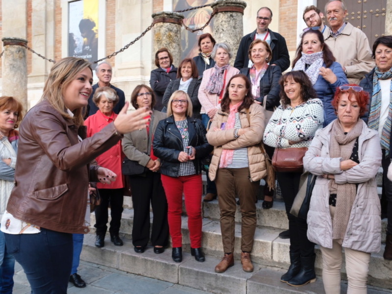 Un grupo de personas posa para una foto en los escalones de un edificio histórico.