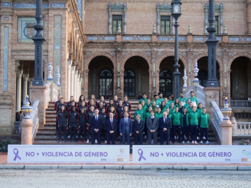 Gruppo di persone in posa davanti a un palazzo storico con un cartello che dice 'NO + VIOLENCIA DE GÉNERO'.