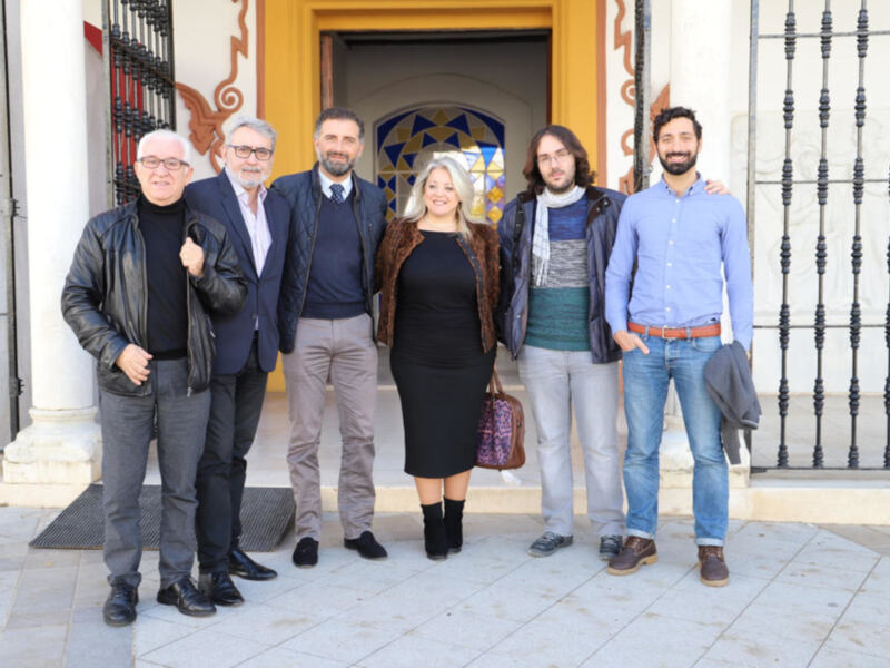 Grupo de personas posando en el exterior de un edificio con arquitectura tradicional.