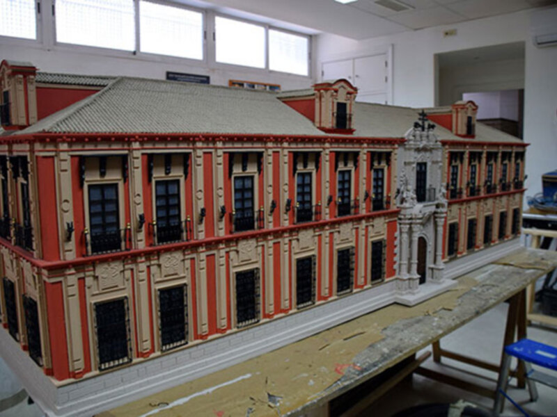 Maqueta de edificio clásico con detalles arquitectónicos en proceso de construcción en taller.