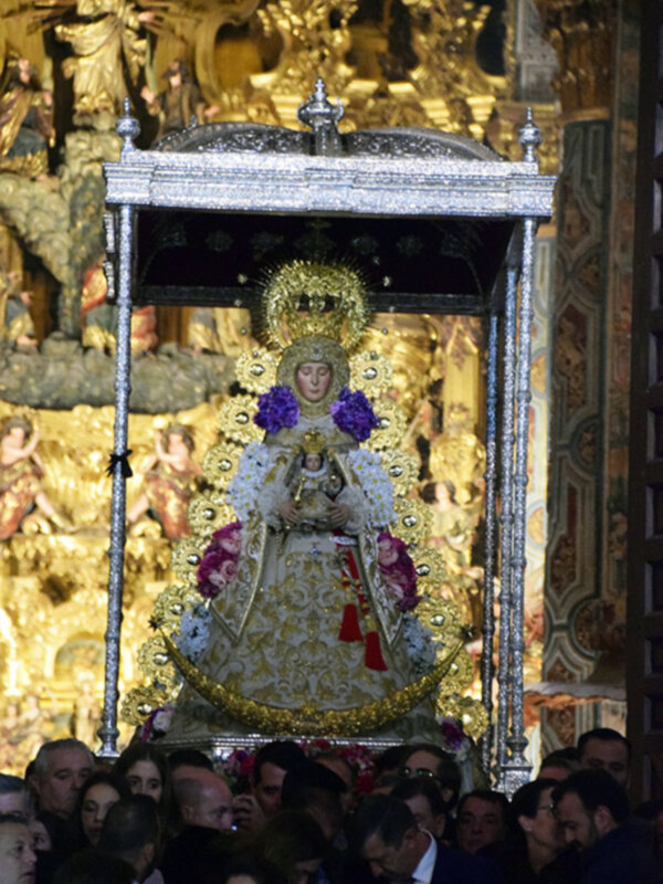 Imaginación de una procesión religiosa con una imagen venerada en el centro, rodeada por una multitud de fieles.