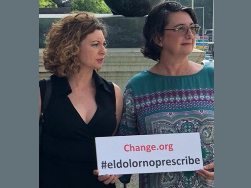 Damas con pancarta que dice '#eldolornorprescribe' en apoyo a Change.org.