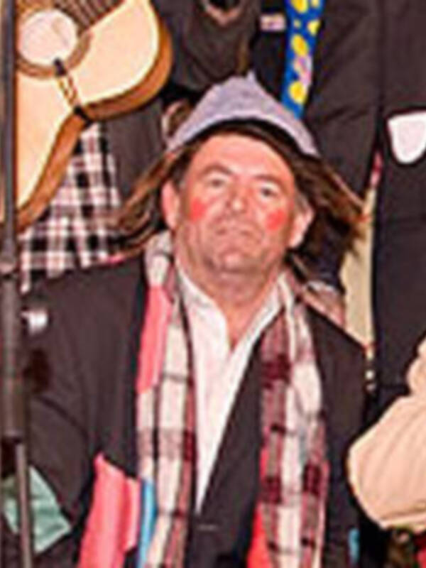 Un hombre con sombrero y bufanda, posiblemente en un evento cultural o festivo.