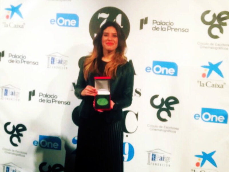 Celebración del 74º Festival de Cine de Barcelona con una ganadora sosteniendo un premio en mano.