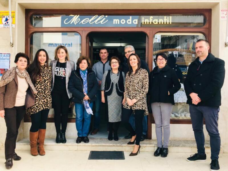 Equipo de trabajo en la entrada de una tienda de moda infantil en España.