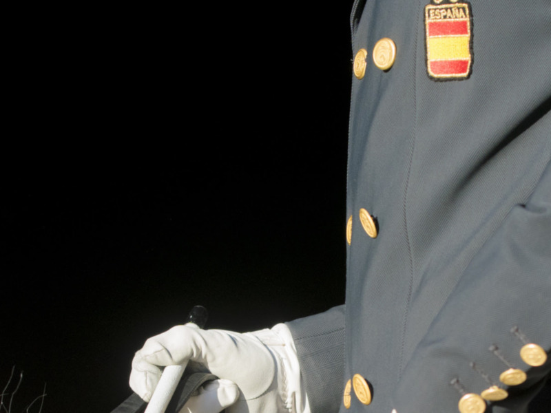 Un oficial de policía en uniforme español, con el escudo nacional en la chaqueta, en una escena de acción.