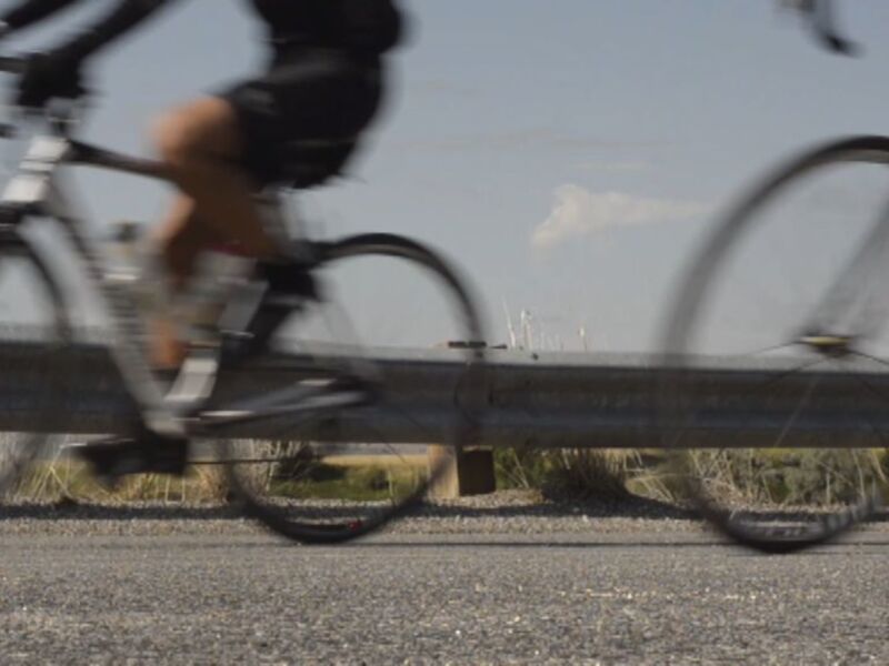 Bicicletas en movimiento, ciclista en primer plano, fondo borroso