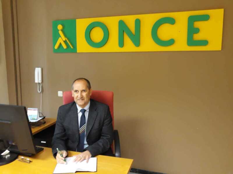 Director de ONCE en su oficina, firmando documentos.