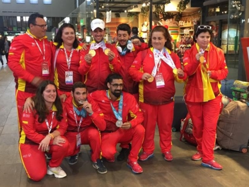 Equipo español de atletismo posando con sus medallas en un centro comercial.