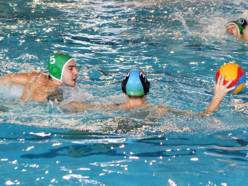Jugadores de waterpolo en acción durante un partido en piscina.