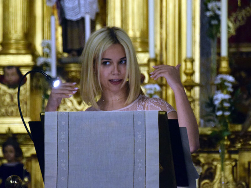 Persona hablando en un podio en un entorno ornamental y dorado, posiblemente en una iglesia o lugar de culto.