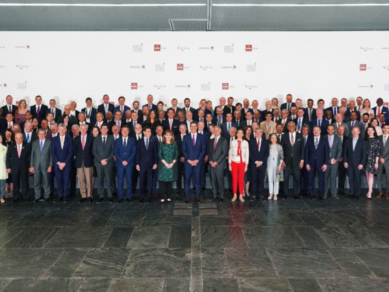 Galería de retratos de líderes y profesionales en trajes formales, posando en fila en un evento formal.