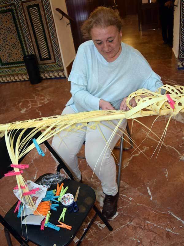 Una persona trabajando en un proyecto de artesanía, usando clips para sujetar un material flexible en forma de estructura.