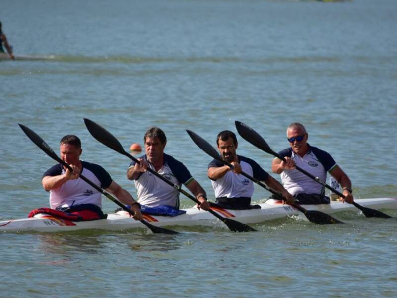 Equipo de canoas en competencia en un lago.