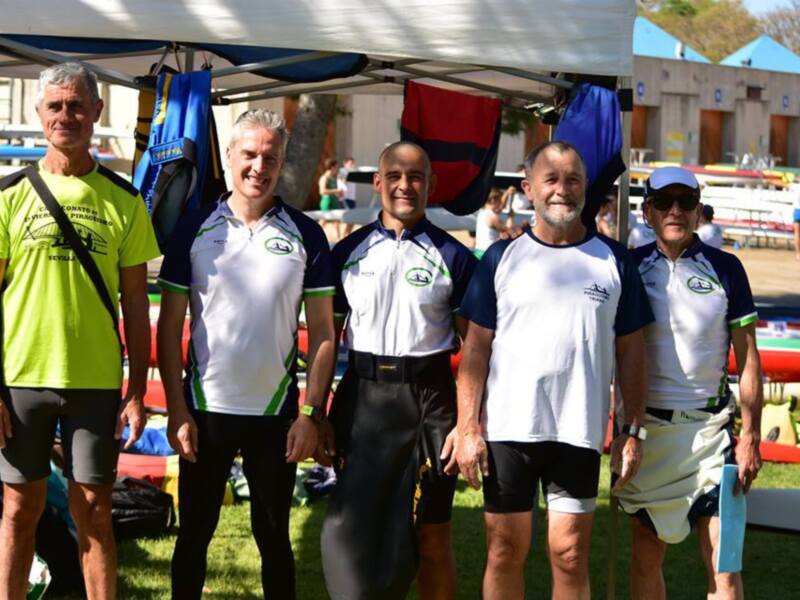 Equipo de atletas posando con banderas de clubes en un evento deportivo.