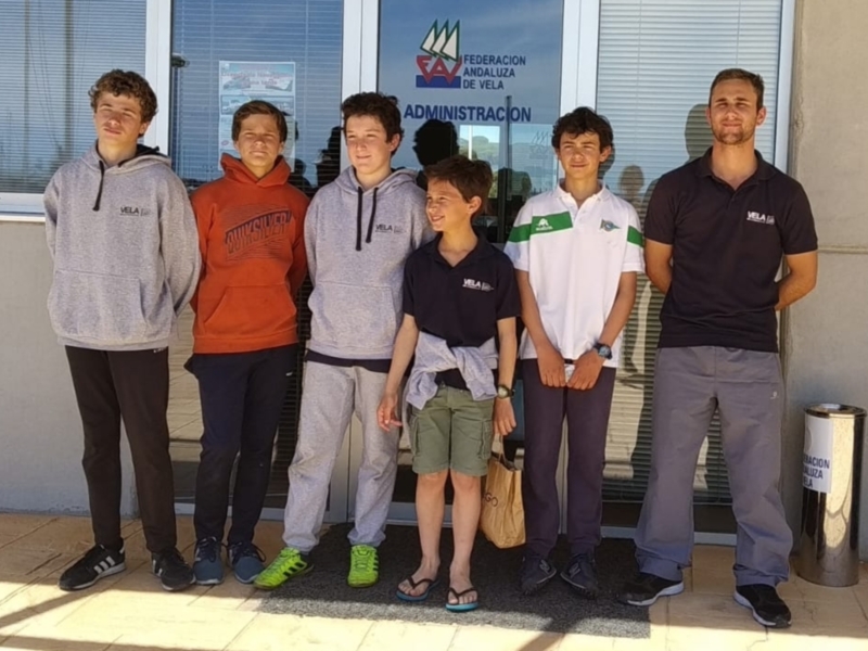 Equipo de jóvenes veleros junto a un adulto en la Federación Andaluza de Vela.