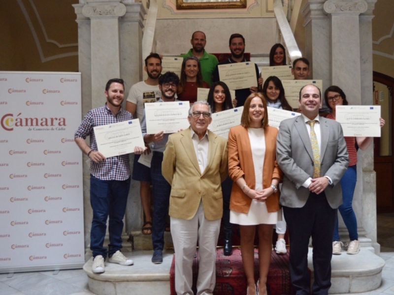 Grupo de personas recibiendo certificados en un acto de la Cámara de Comercio de Cádiz.