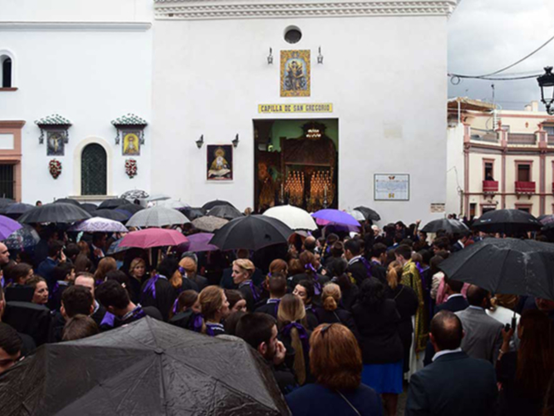 Celebración bajo la lluvia en la Capilla de San Diego, con una multitud vestida de luto.