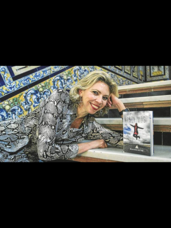 Autora posa junto a su libro 'Anónimos' en un entorno decorativo con azulejos.